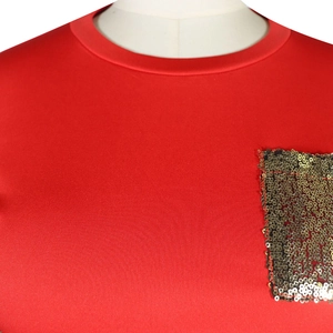 Detail eines roten Rundhals-Tops mit dekorativer goldener Paillettentasche auf der Brust