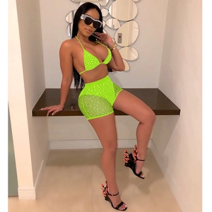 Detail of neon green bikini top and mesh shorts with sparkling rhinestone accents