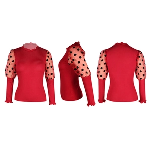 Détail du haut en maille rouge avec manches bouffantes en mesh à pois noirs