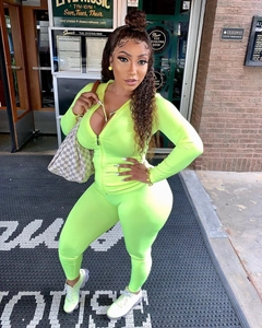 Buitenopname van een fluorescerend groen trainingspak voor dames met hoodie en legging