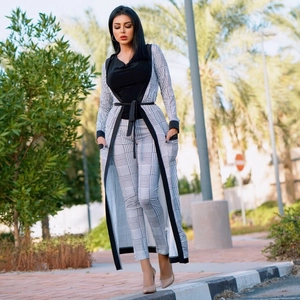 Dettaglio del set cardigan e pantaloni con motivo pied-de-poule e cintura in vita