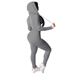 Zijaanzicht van het donkergrijze trainingspak met hoodie en nauwsluitende sportlegging