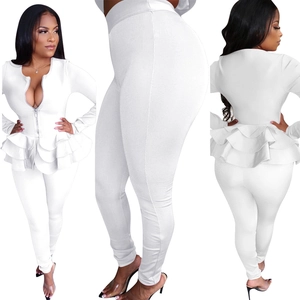 Détail d'un ensemble blanc deux pièces avec haut à basque et pantalon ajusté