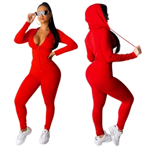 Rood tweedelig sportpak voor dames met een jasje met capuchon en een strakke lange broek