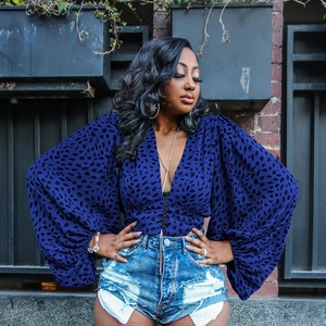 Detail of dark blue leopard print blouse featuring deep V-neck and puff lantern sleeves