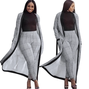 Dettaglio del set elegante con cardigan lungo a quadri bianco e nero e pantaloni slim