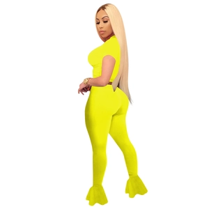 Detail of high-waist flared pants and mesh crop top in bright yellow athletic set