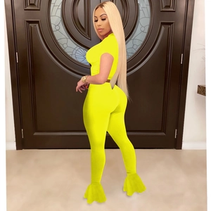 Detail view of neon yellow flared leggings and cropped short sleeve top sports set