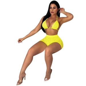 Detail of neon yellow two-piece mesh set with sparkling sequins and halter neck bikini