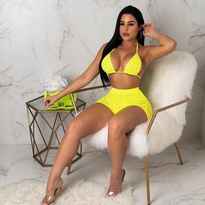 Detailed macro view of fluorescent yellow sequins and rhinestones on high-waist shorts set