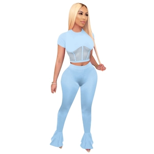 Detail of light blue crop top with grey mesh waist panel and flared yoga leggings