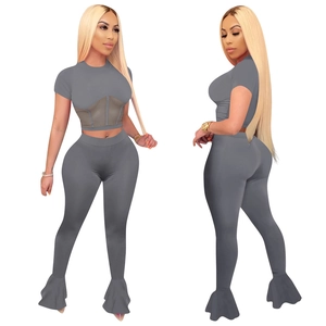 Detail of grey sports set featuring mesh patchwork top and exaggerated flare pants