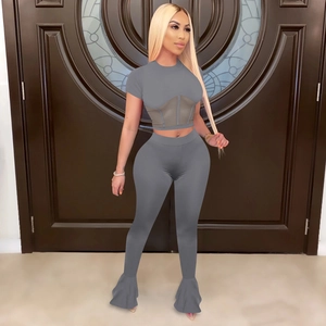 Detail of grey two-piece set featuring mesh splice crop top and flared leggings