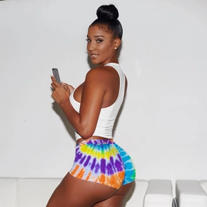 Side view of white crop top and colorful tie-dye printed biker shorts for women