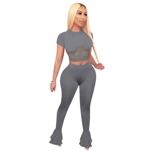 Detail view of two-piece grey sports set showing mesh patchwork and bell bottom flare pants