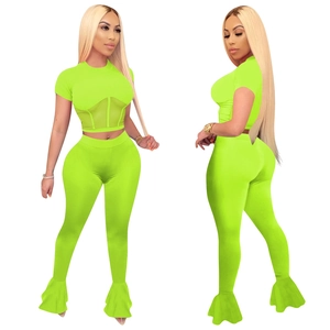 Detail of neon green mesh patchwork crop top and flared leggings two-piece set