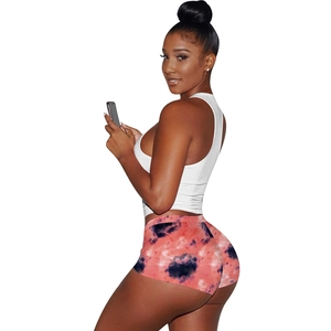 Detail of white slim-fit tank top and tie-dye shorts set on a fit female model