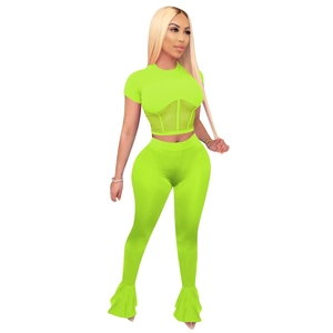 Detail showing the neon green crop top with mesh paneling and flared ruffle pants hem
