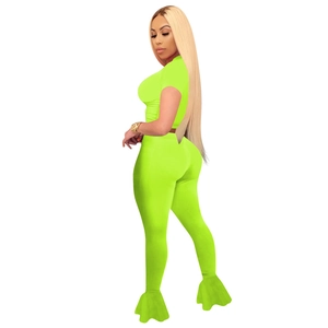 Detail of neon green two-piece set featuring crop top and flared leggings with mesh patchwork