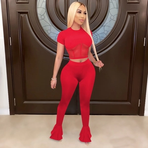 Detailed view of red two-piece set featuring mesh splice crop top and flare trousers