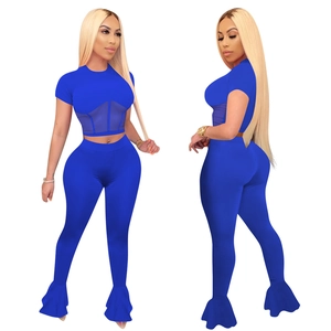 Women's dark blue two-piece set featuring mesh splice crop top and flare leg yoga pants