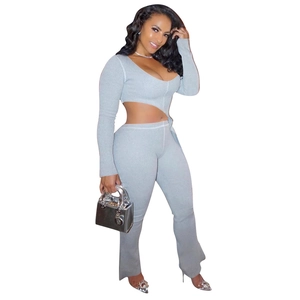 Detail view of grey knit two-piece set with long sleeve cutout crop top and flared pants