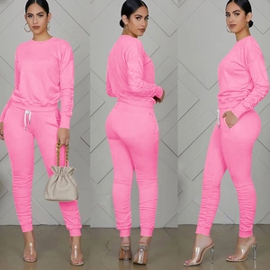 Vista su tre lati del set sportivo rosa due pezzi con dettagli arricciati e tasche