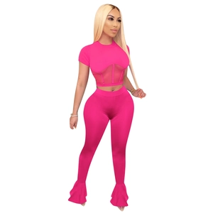 Detail of neon pink tracksuit featuring mesh patchwork crop top and flared leggings set