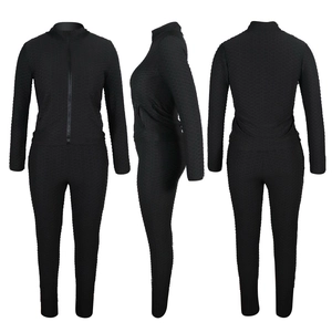 Détail de l'ensemble deux pièces noir à texture alvéolée avec veste zippée à col montant