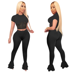 Detail of mesh patchwork on black two-piece set featuring flare leg trousers and crop top