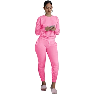 Dettaglio della tuta rosa due pezzi con polsini e gambe con design a pieghe