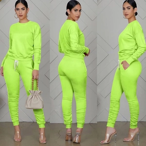Vista tripla del completo due pezzi verde neon con maglia a maniche lunghe e pantaloni sportivi