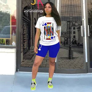 Detail of white round neck T-shirt with playing card print and blue cycling shorts