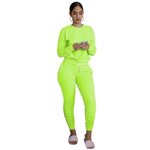 Dettaglio del set due pezzi verde neon con pantaloni arricciati e polsini a coste