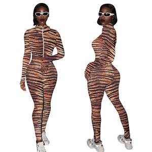 Macro detail of high-elastic tiger print fabric and zipper on women's two-piece tracksuit