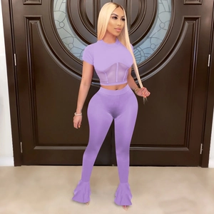 Detail of lavender two-piece set featuring mesh splice crop top and flared leggings