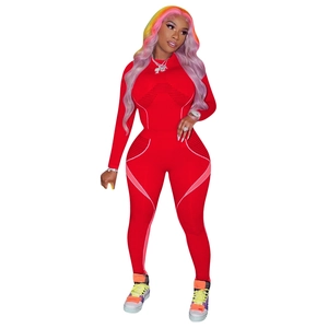 Détail d'un ensemble de yoga rouge ajusté avec contours roses et tissu mesh respirant
