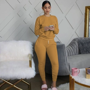 Dettaglio del set lounge giallo senape con pantaloni jogger arricciati e felpa a maniche lunghe
