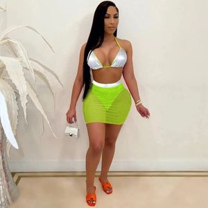 Detail of neon green mesh mini skirt with sequin accents and silver metallic bikini top