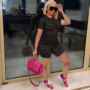Dettaglio dei motivi a rete tagliati al laser sul completo streetwear nero da donna