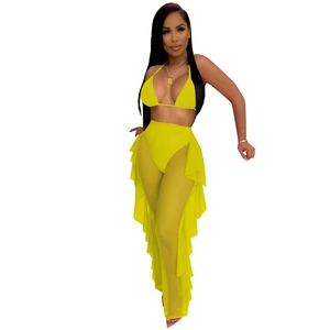 Detailed view of the bright yellow mesh trousers featuring ruffled sides and sheer fabric
