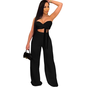 Detail of black halter wrap crop top and high-waisted wide-leg trousers two-piece set
