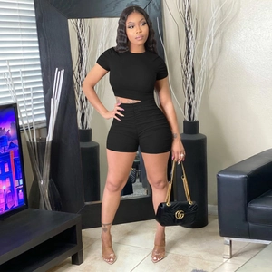 Women's black ribbed knit two-piece set featuring short sleeve crop top and bodycon shorts