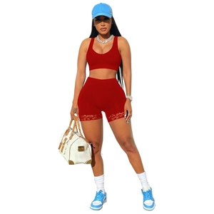 Red two-piece athletic yoga set with lace trim shorts and matching sports bra top