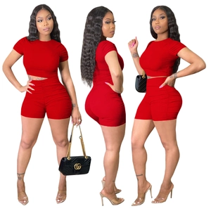 Three views of red ribbed short set featuring ruched sleeves and side drawstring shorts