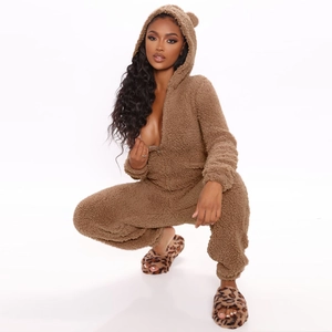 Détail d'une combinaison pyjama marron en peluche avec capuche à oreilles