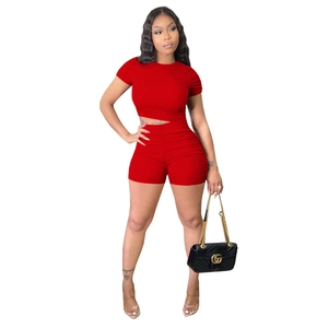 Detail of red ribbed knit two-piece set featuring ruched sleeves and bodycon fit