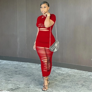 Détail de la robe maxi moulante rouge avec découpes horizontales de style effiloché
