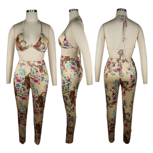 Detailansicht von Tiger- und Blumenprint auf High-Waist-Hose und Halterneck-Bikini-Top