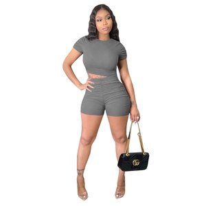 Detail of ribbed knit grey two-piece set featuring ruched sleeves and bodycon shorts
